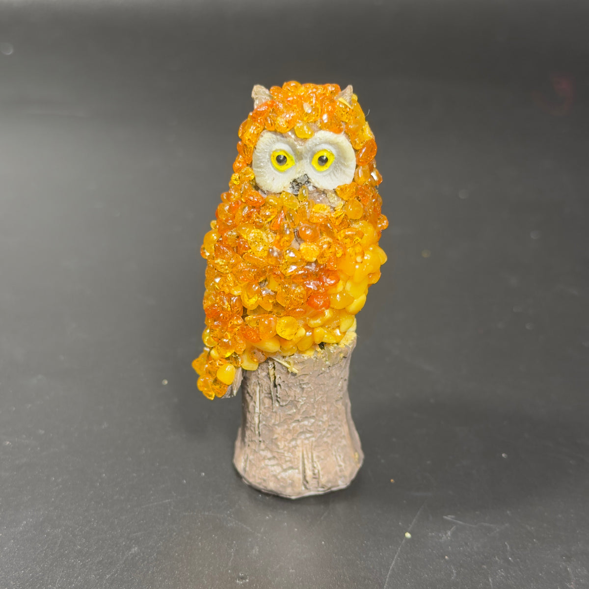 Unedited workshop photo of the orange amber mosaic owl standing on its tree stump base