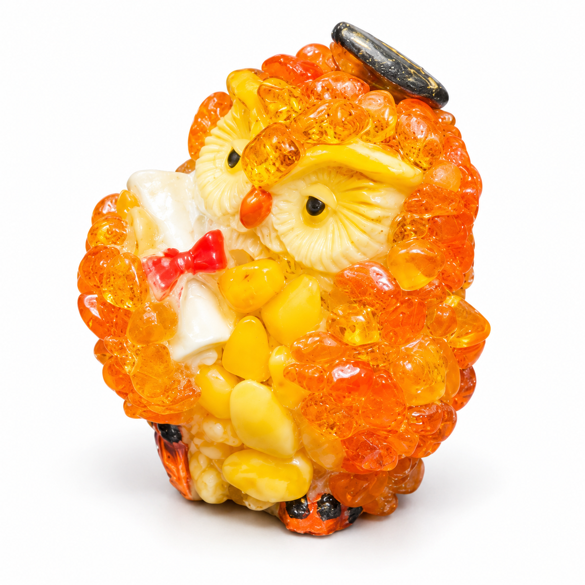 Orange and yellow graduation owl figurine on a white studio background