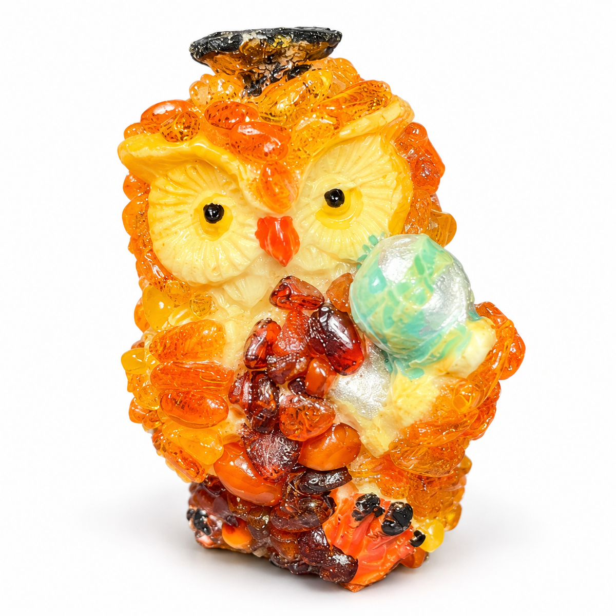 Cream faced golden orange owl with aqua globe on a white studio background