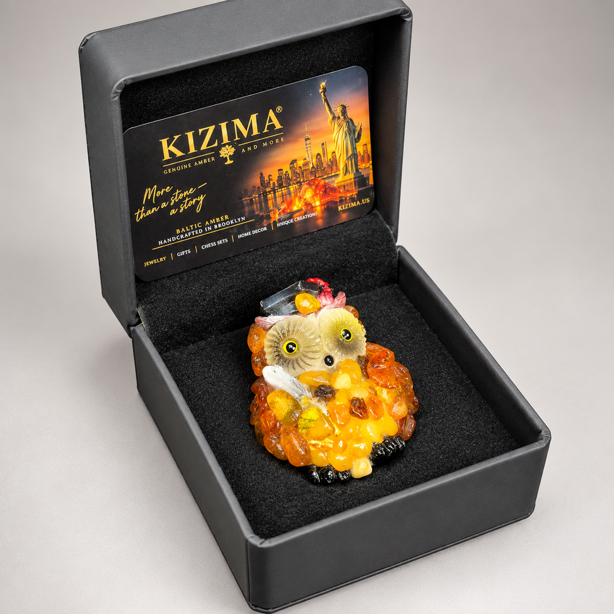 Graduation owl amber magnet in its open charcoal-gray KIZIMA gift box, ready to give