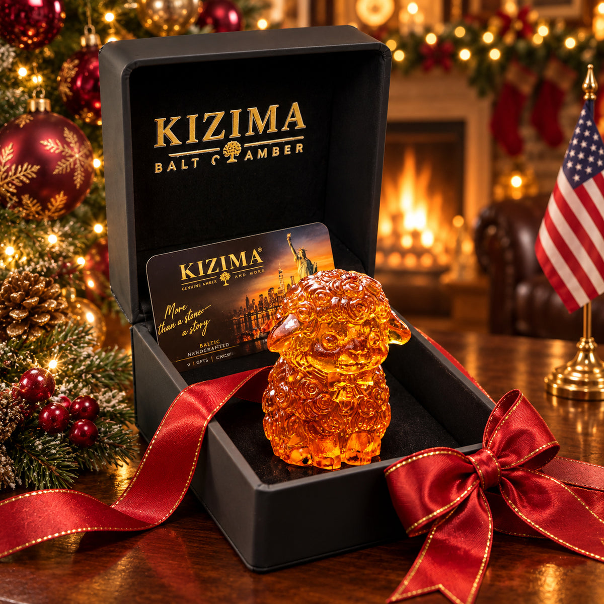 Amber sheep with a sculpted bow tie in a black KIZIMA presentation box with red ribbon, Christmas ornaments and an American flag.