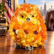 Made in USA small orange and yellow natural Baltic amber owl figurine in an office setting.