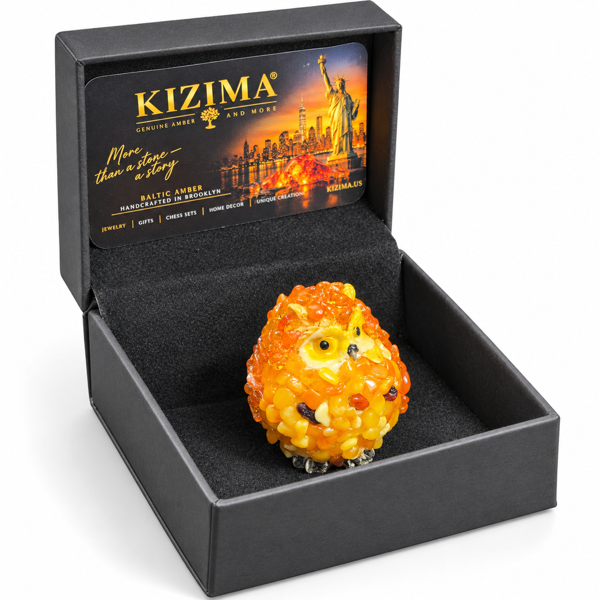 Orange and yellow owl figurine with a KIZIMA box on a white background