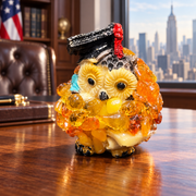 Made in USA natural Baltic amber mini graduation owl with red tassel on an oak desk in an American office.