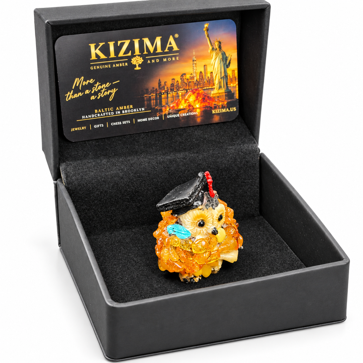 Graduation owl in its open black KIZIMA presentation box on a white studio background