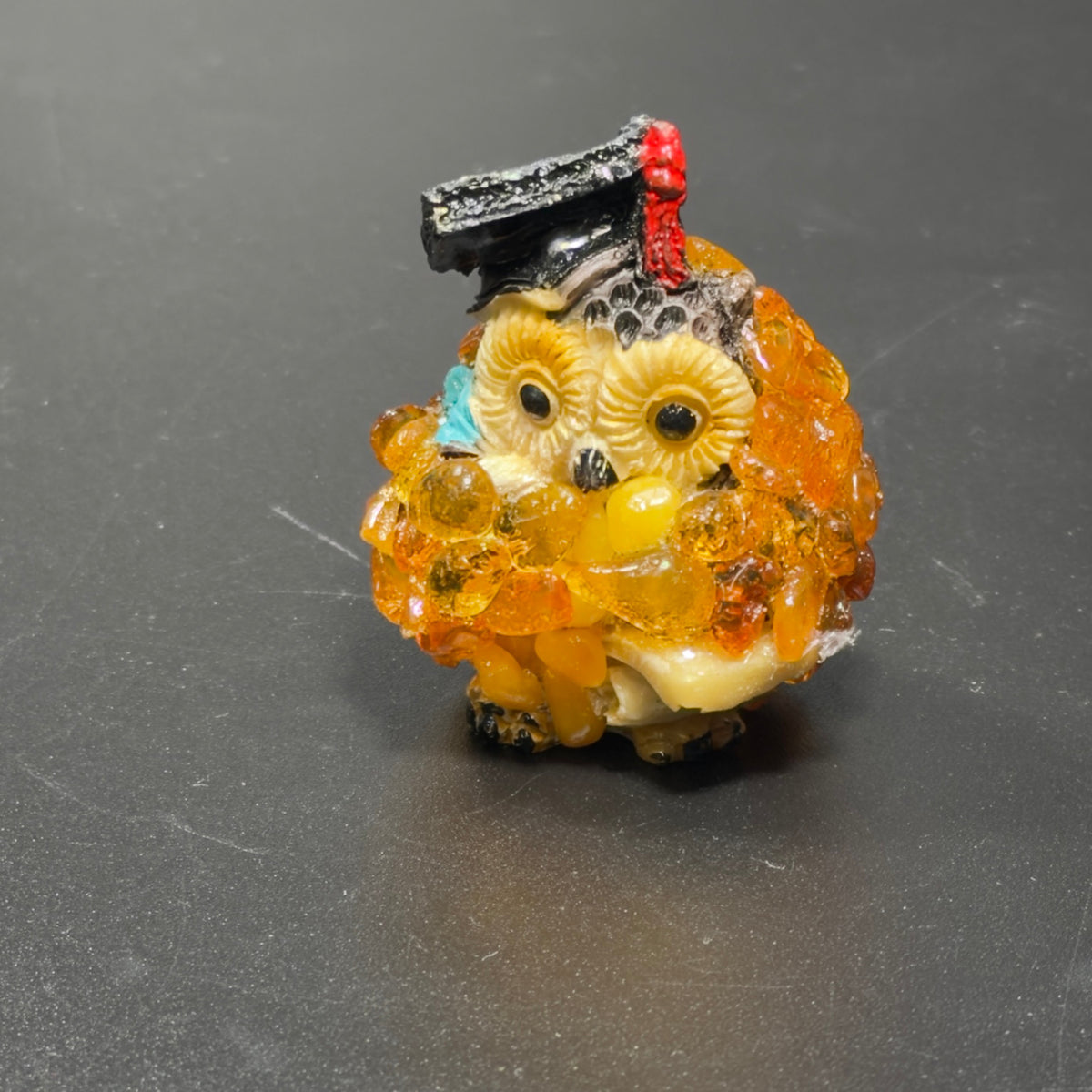 Original photograph of the golden-orange graduation owl with black cap and red tassel