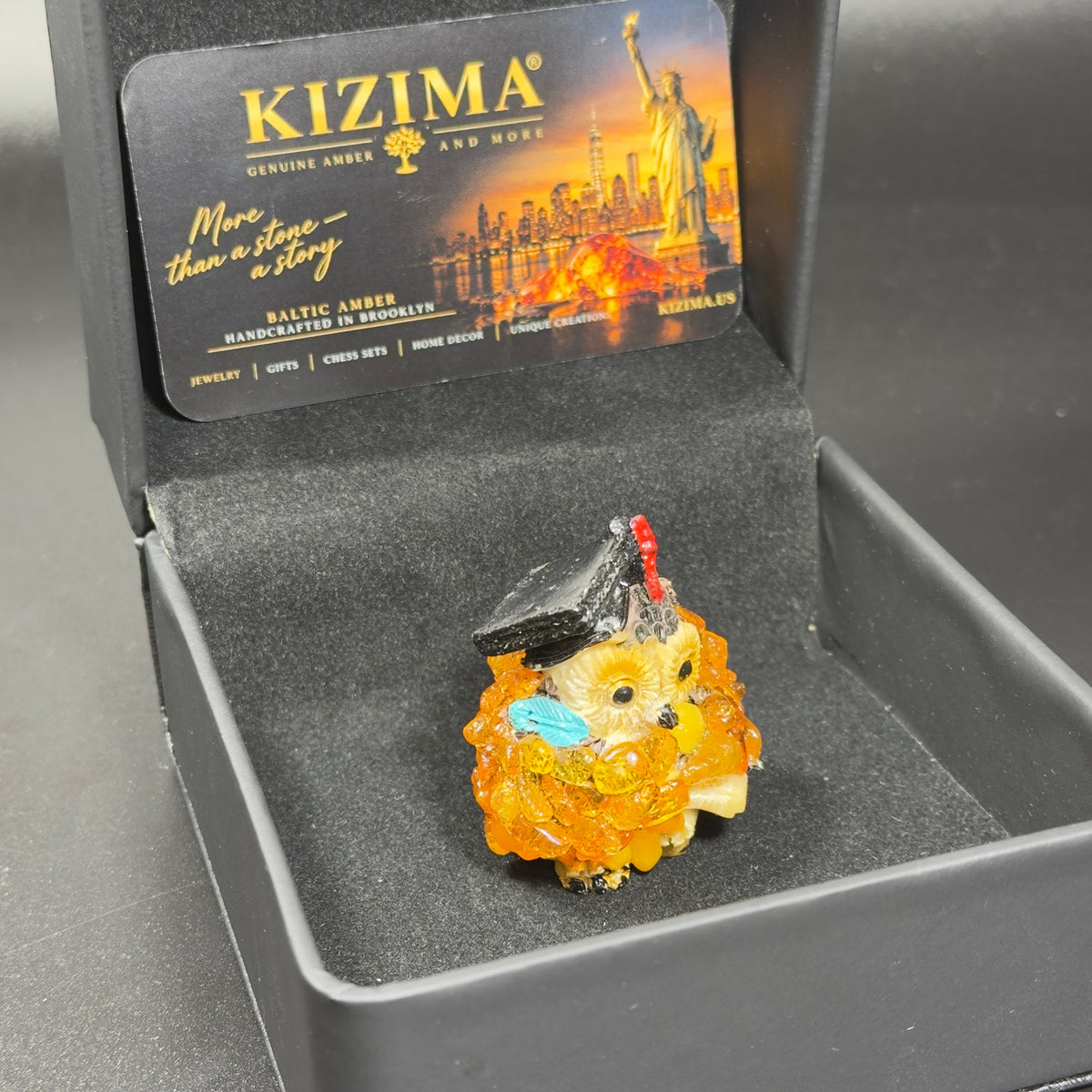 Original photograph of the graduation owl inside its open black KIZIMA presentation box