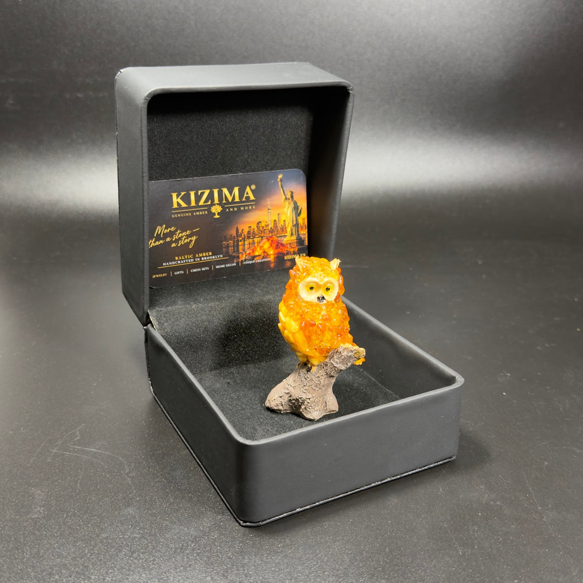 Original photograph of OWL24 owl figurine inside its open black KIZIMA gift box