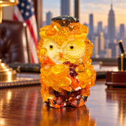 Made in USA natural Baltic amber mini graduation owl with a cap and stole in an office interior.
