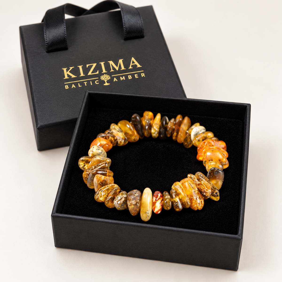 Honey and olive amber nugget bracelet resting on clean black velvet inside a KIZIMA gift box.