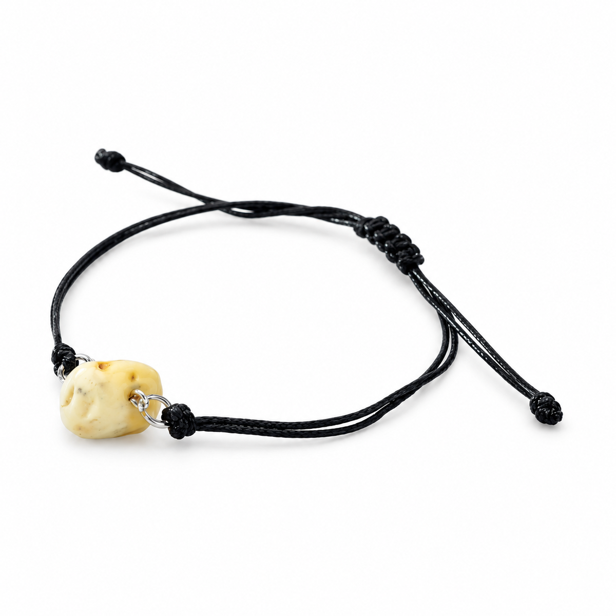 KIZIMA cream amber nugget on adjustable black cord bracelet on pure white background.