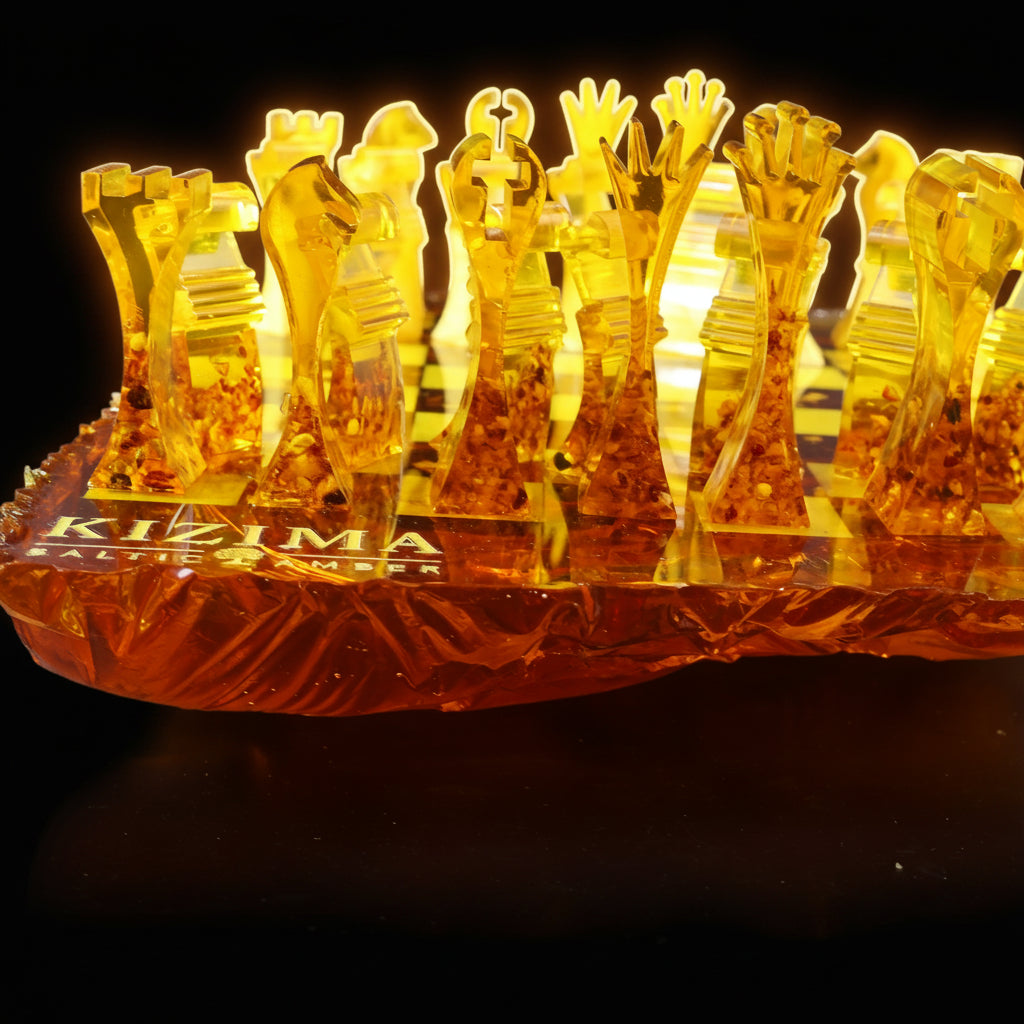 Close-up of handcrafted KIZIMA® Baltic amber chess pieces with sculptural modern design and artistic irregular amber chess board edge.