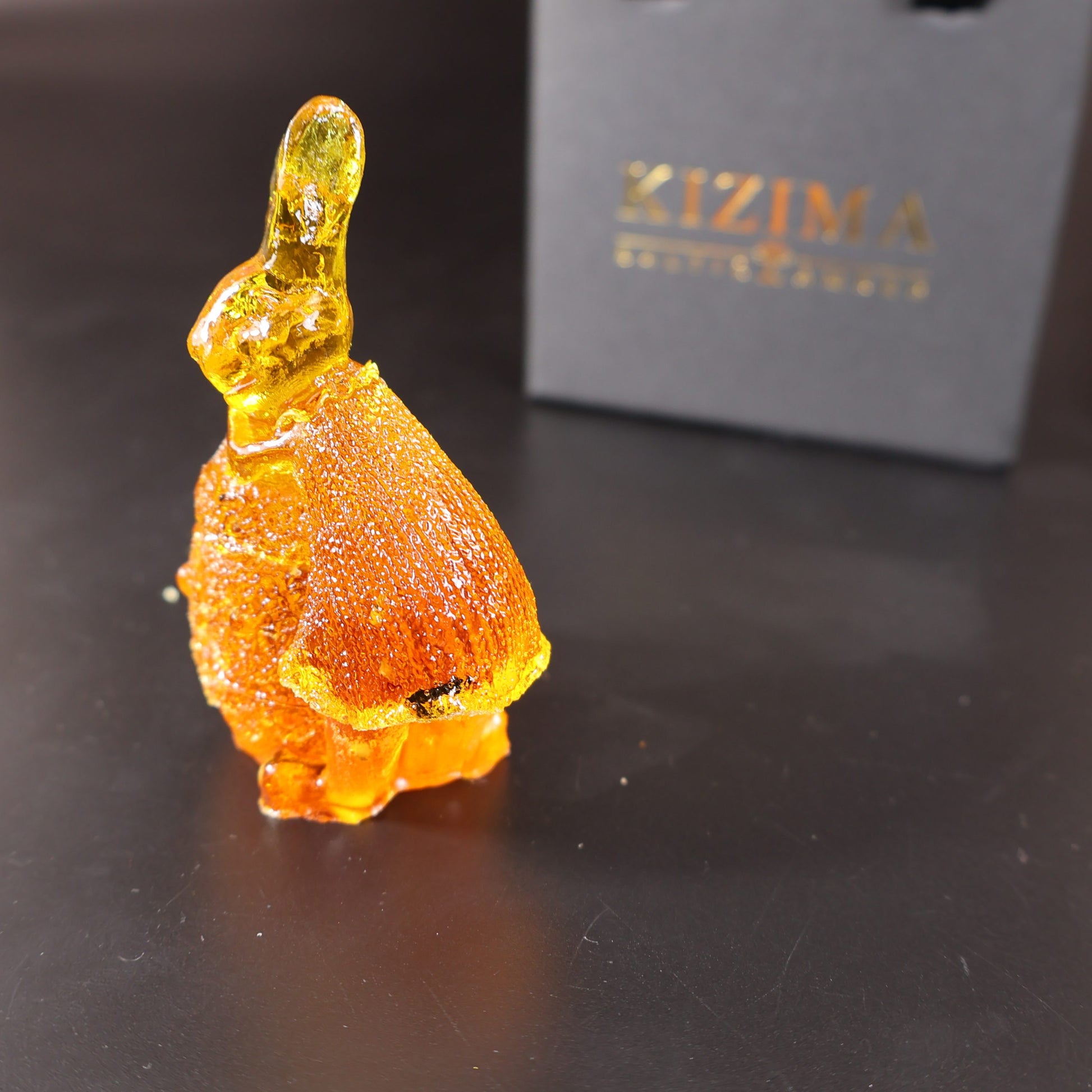 Handmade Baltic amber bunny on egg by KIZIMA® USA — natural amber decor, angled view