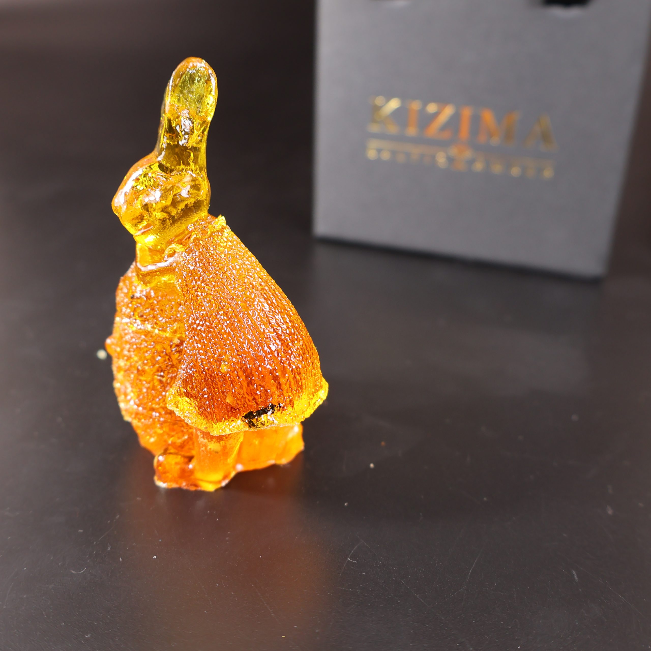 Handmade Baltic amber bunny on egg by KIZIMA® USA — natural amber decor, angled view