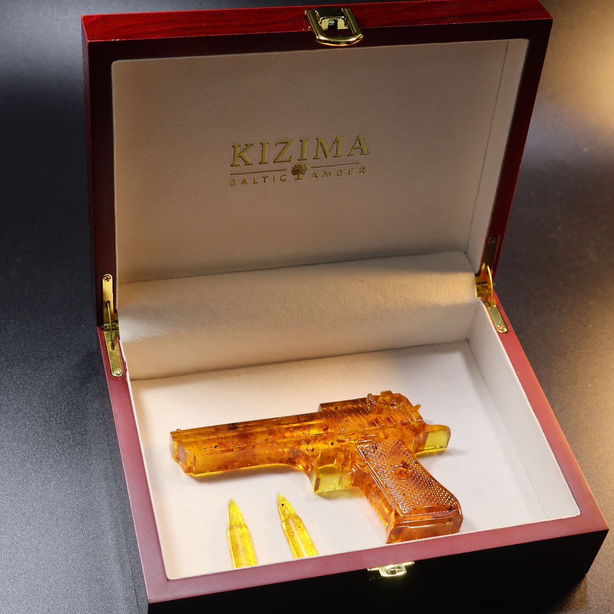 Made in USA Natural Baltic Amber Gun Figurine, Collectible Decor by KIZIMA® — handmade amber pistol sculpture, angled view