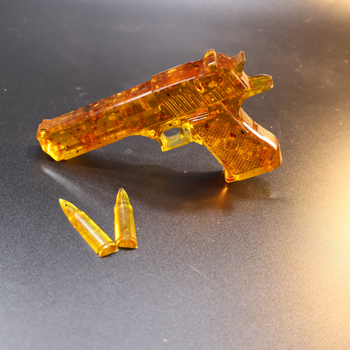 Made in USA Natural Baltic Amber Gun Figurine, Collectible Decor by KIZIMA® — handmade amber pistol sculpture, close-up