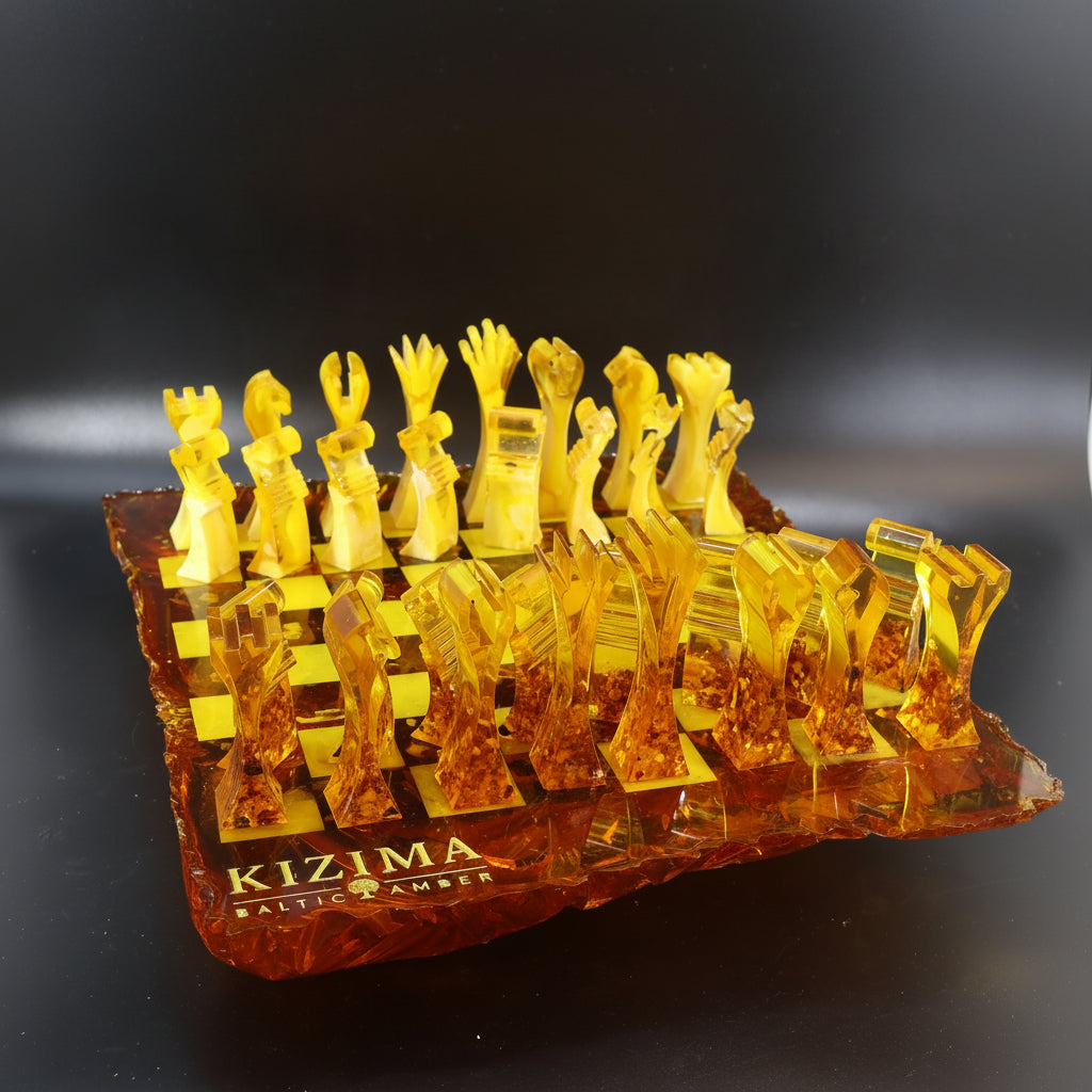 Handcrafted KIZIMA® Baltic amber chess set with sculptural modern chess pieces and artistic irregular amber board on black background.

