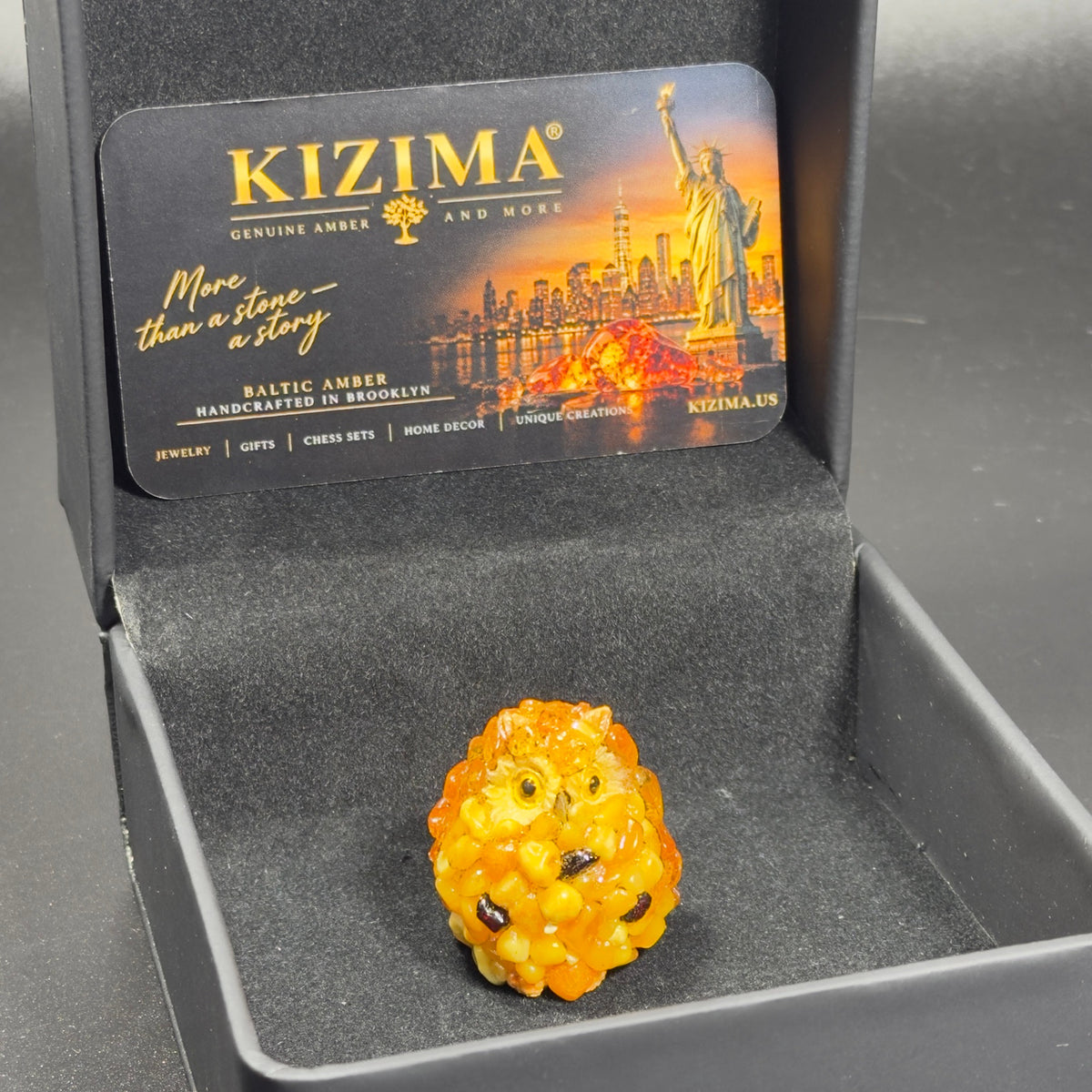 Original photograph of the owl figurine in its open black KIZIMA presentation box