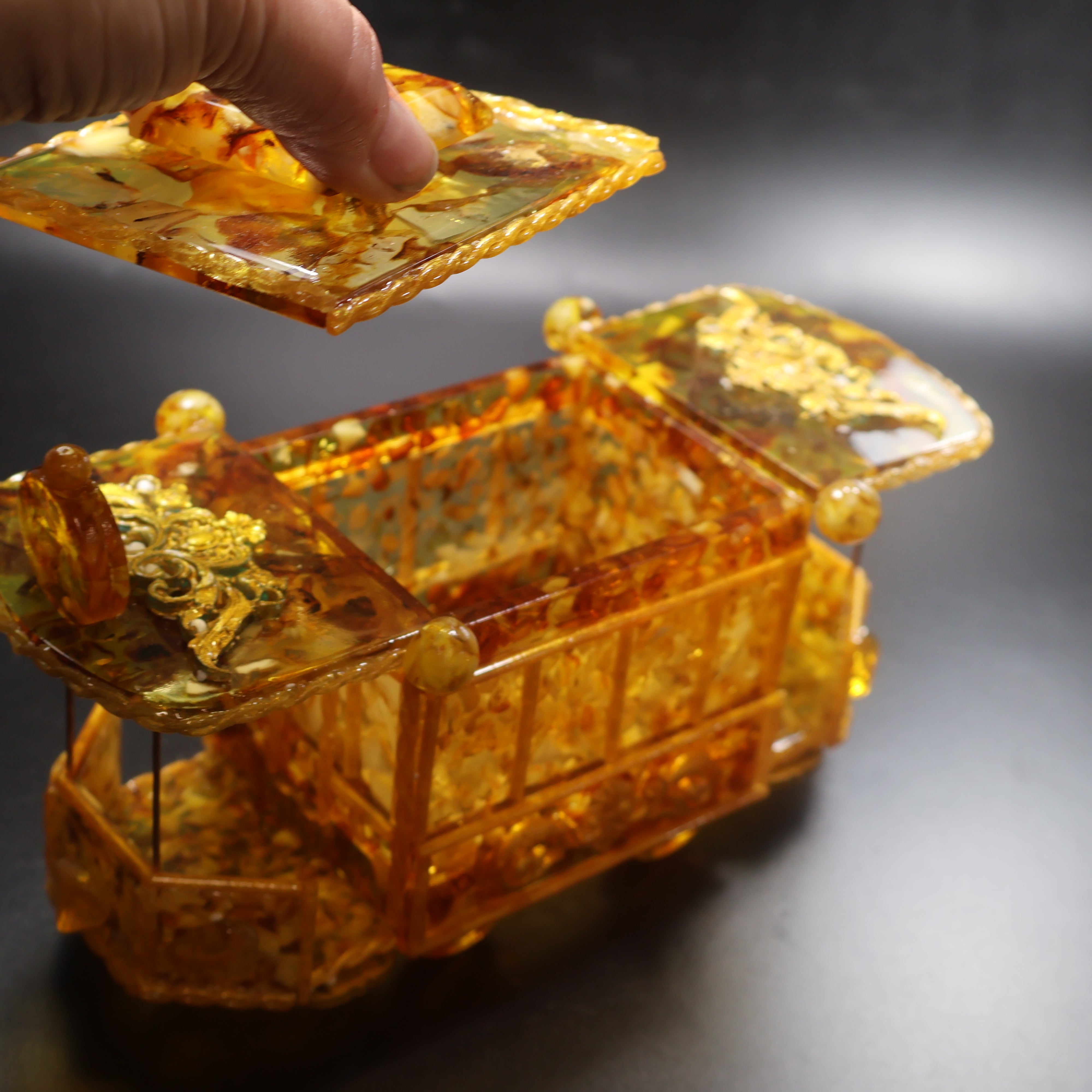 Detail of genuine Baltic Amber windows and honey amber texture on handcrafted vintage tram jewelry box