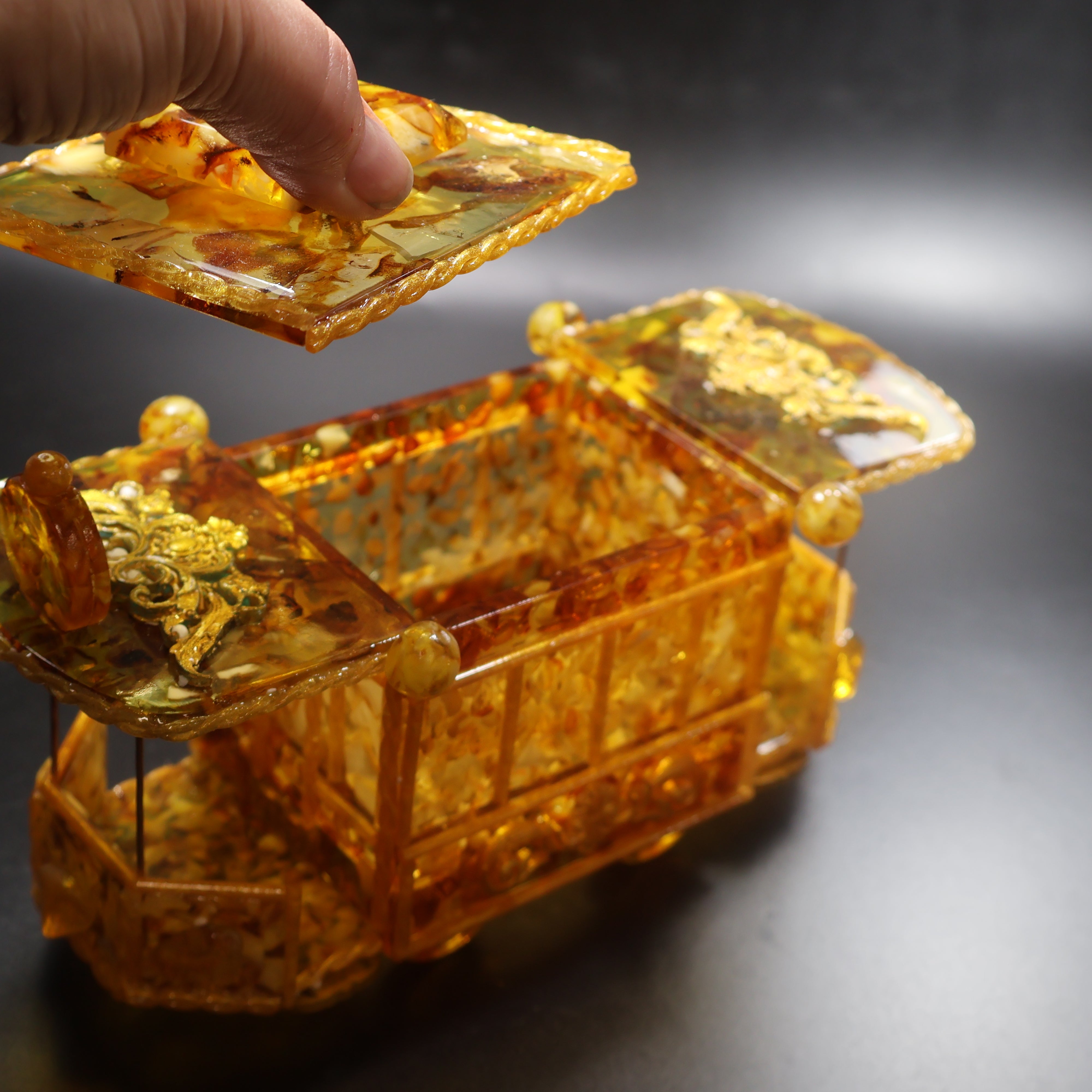 Natural Baltic Amber tram jewelry box held in hand for scale, collectible amber gift by KIZIMA