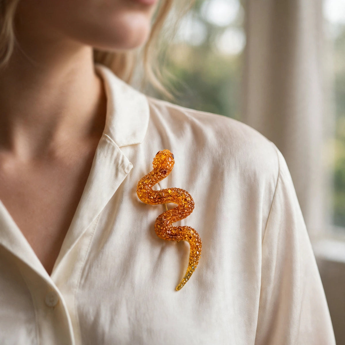 Handmade Baltic amber snake brooch worn on a model — KIZIMA, Made in USA