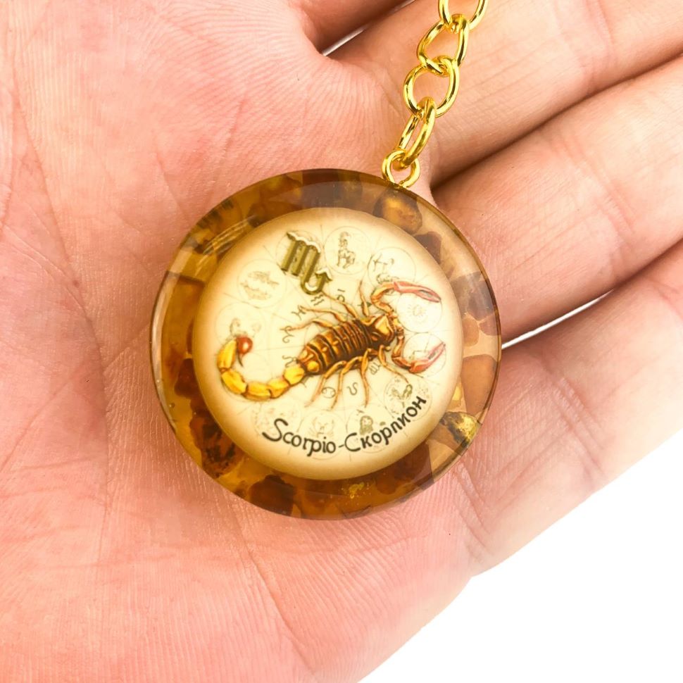 Scorpio zodiac sign Baltic amber keychain in hand scale reference KIZIMA handmade gift