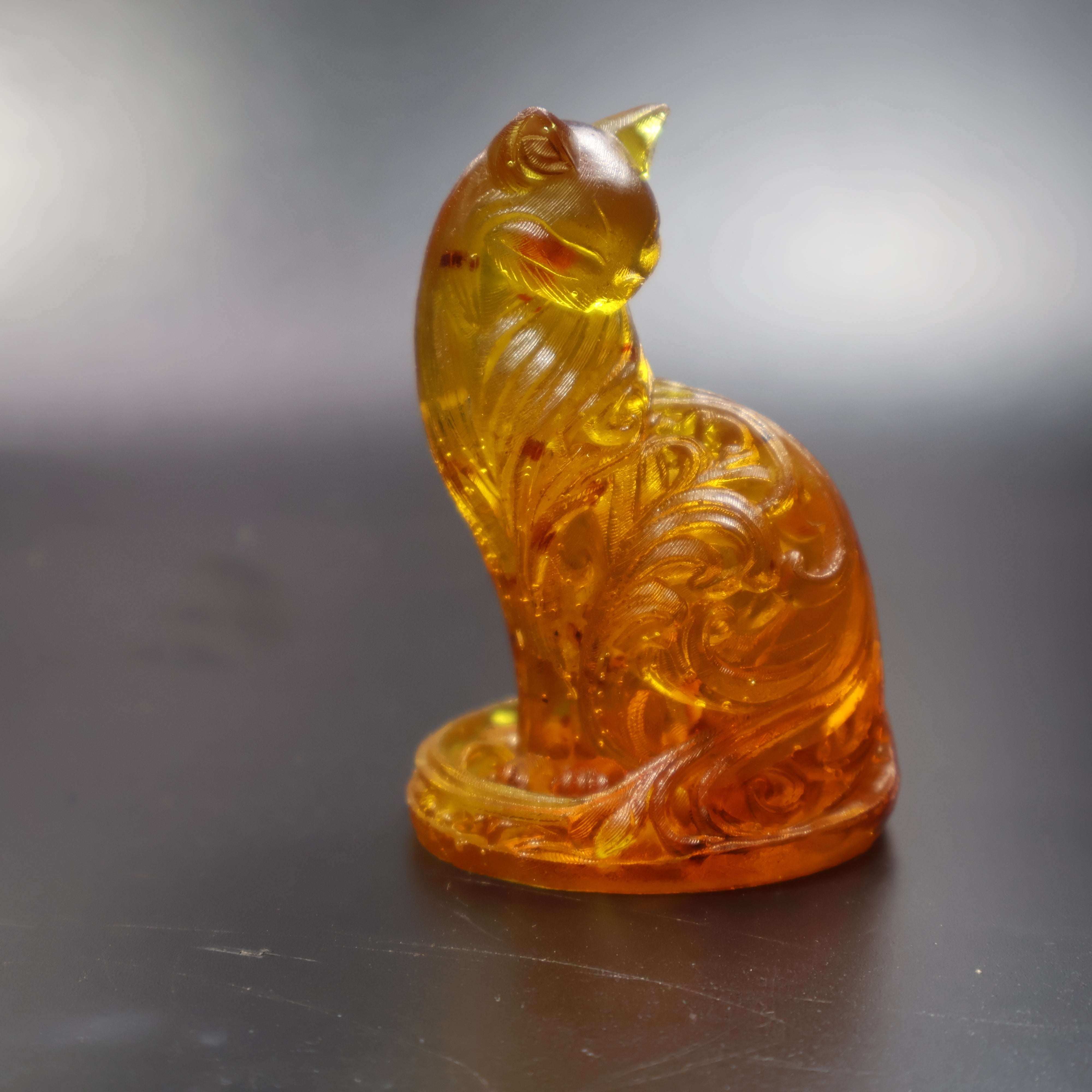 Golden Baltic amber cat figurine with carved scrollwork, handmade in Brooklyn New York