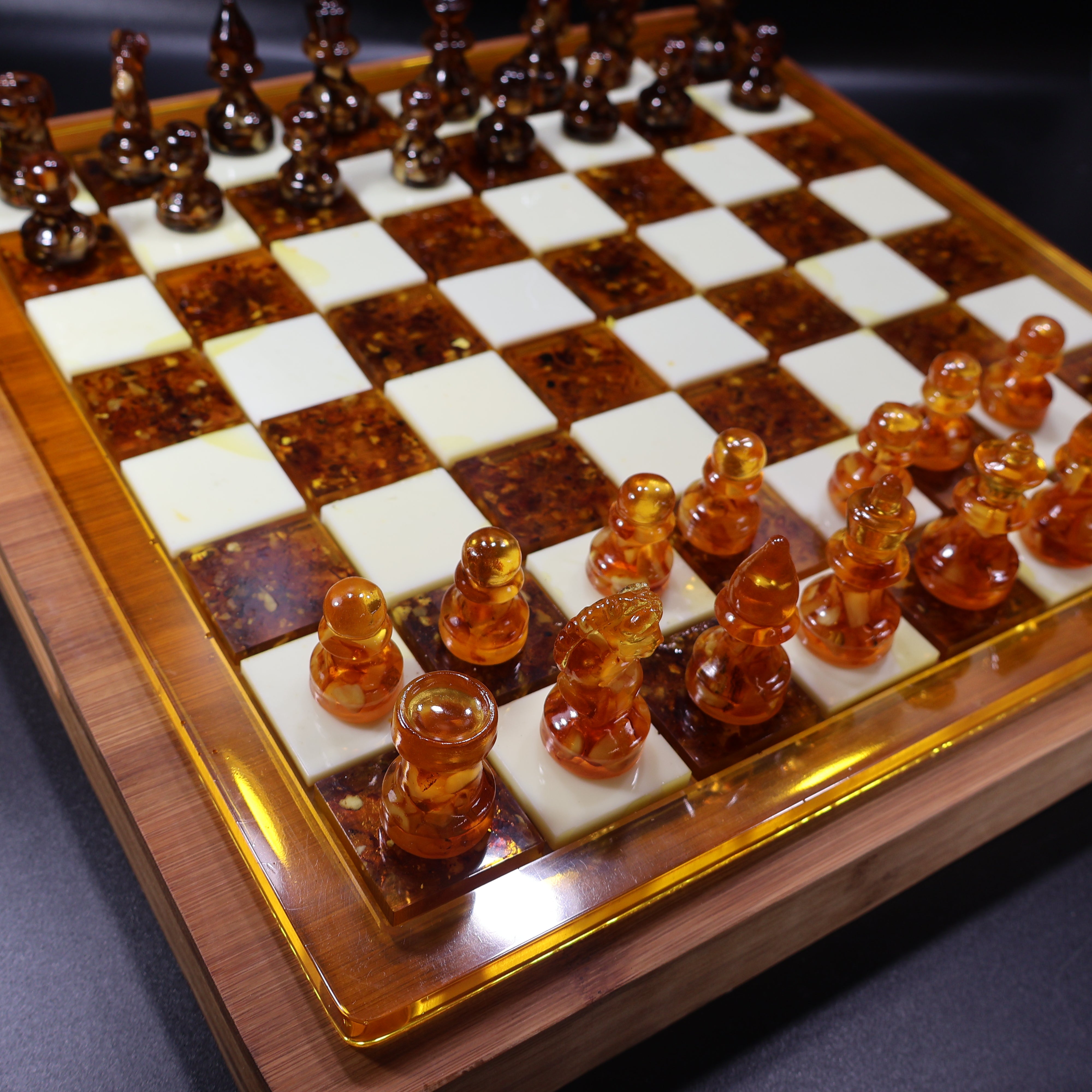 Wood chess board corner with amber inlay squares and brass edge, Brooklyn workshop