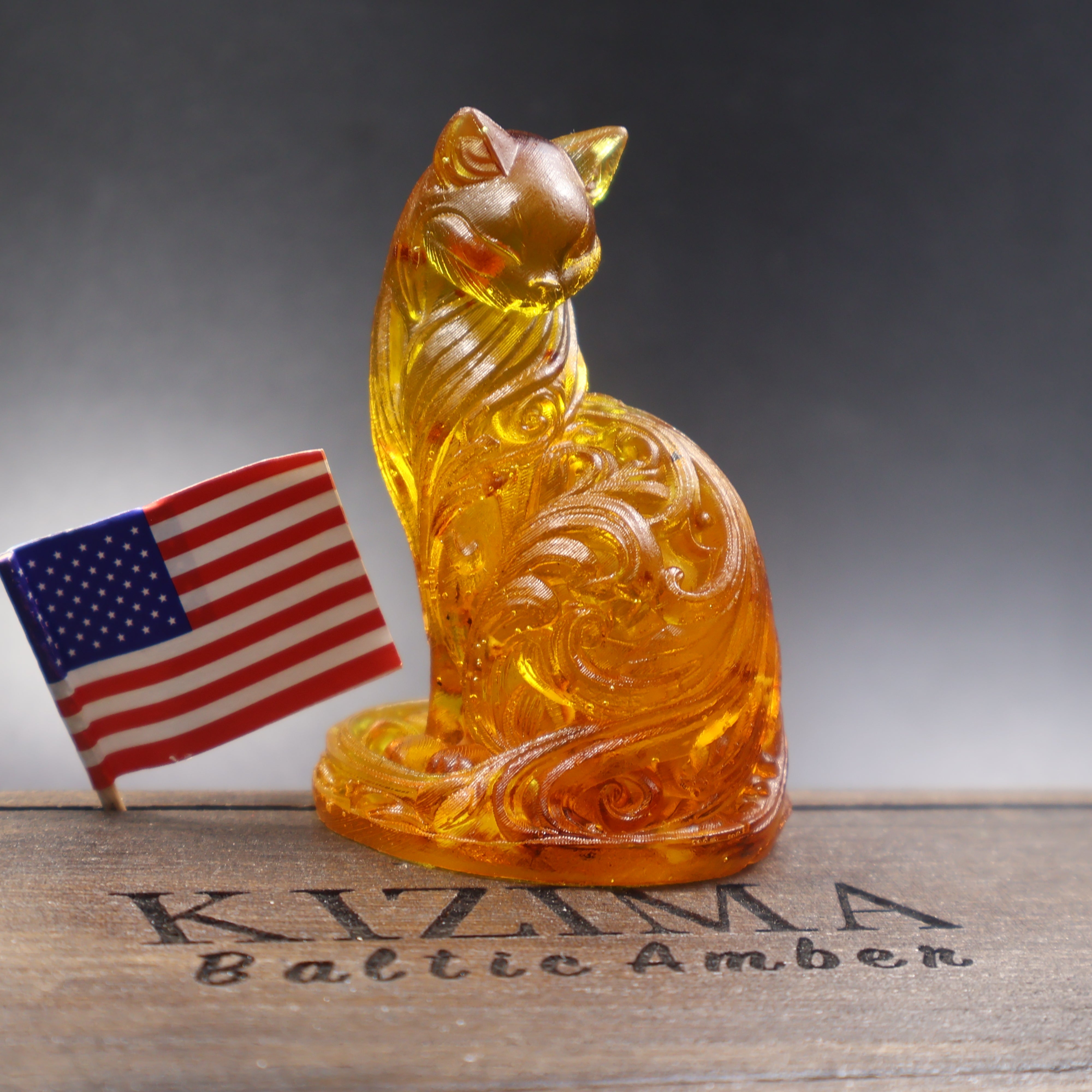 Baltic amber ornamental cat figurine close-up of scrollwork carving, USA amber art