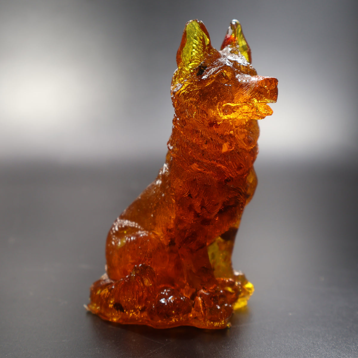 Amber German Shepherd dog statuette sitting alert, deep cognac with natural inclusions