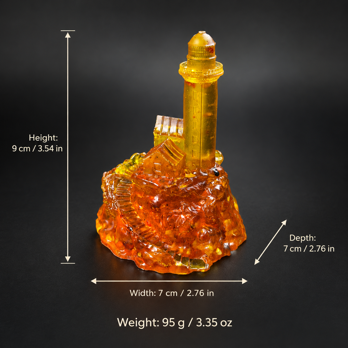 Amber lighthouse figurine with measurement arrows showing height 9 cm, width 7 cm, depth 7 cm, and weight 95 g with inch and ounce equivalents.