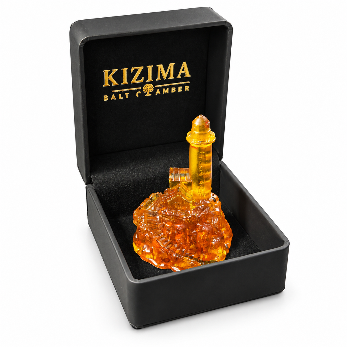 Honey-gold amber lighthouse nestled in its open black KIZIMA gift box with gold logo, photographed on a pure white background.