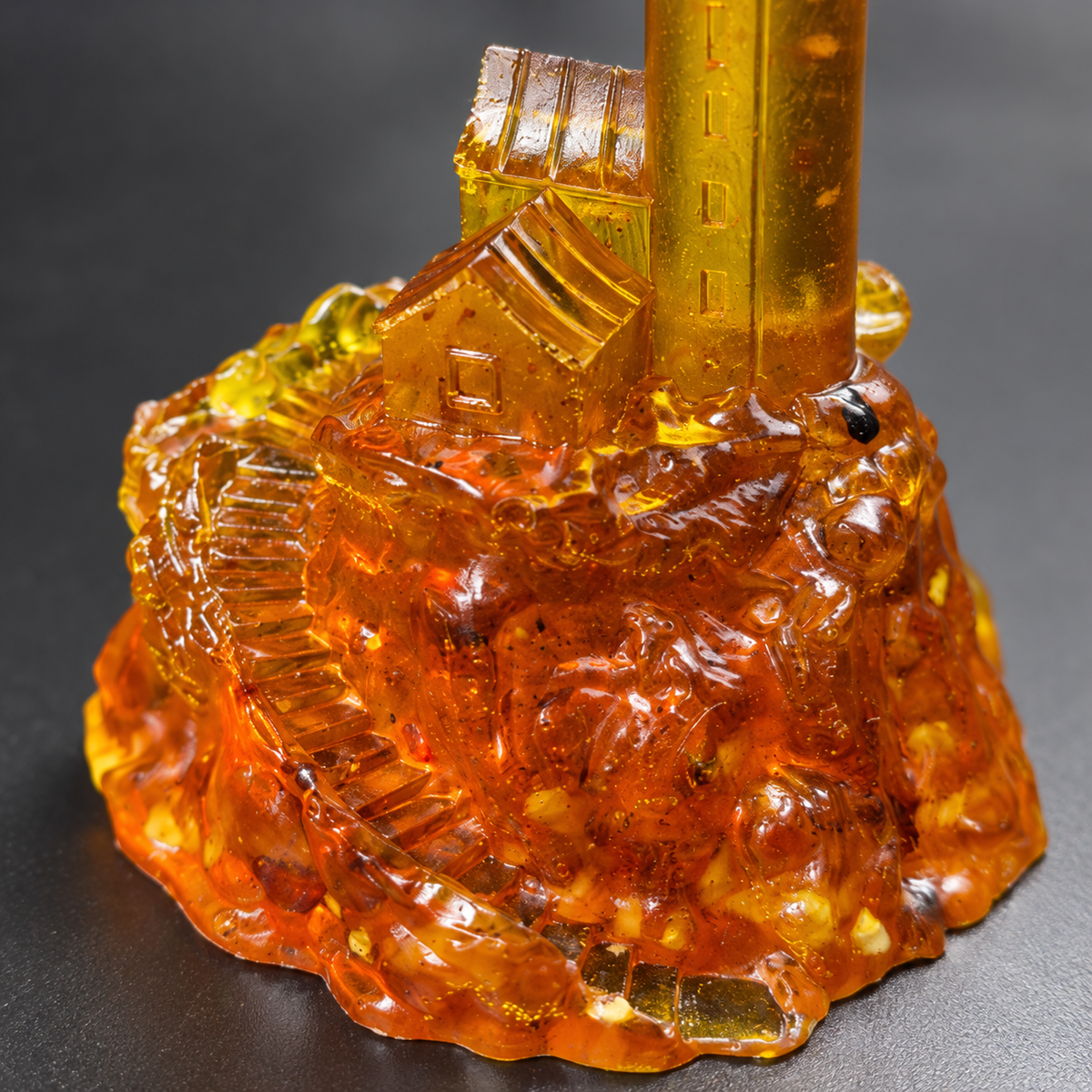 Close-up of the lighthouse’s amber keeper house, winding stairway and cognac-colored rocky base, revealing the original inclusions and polished texture.