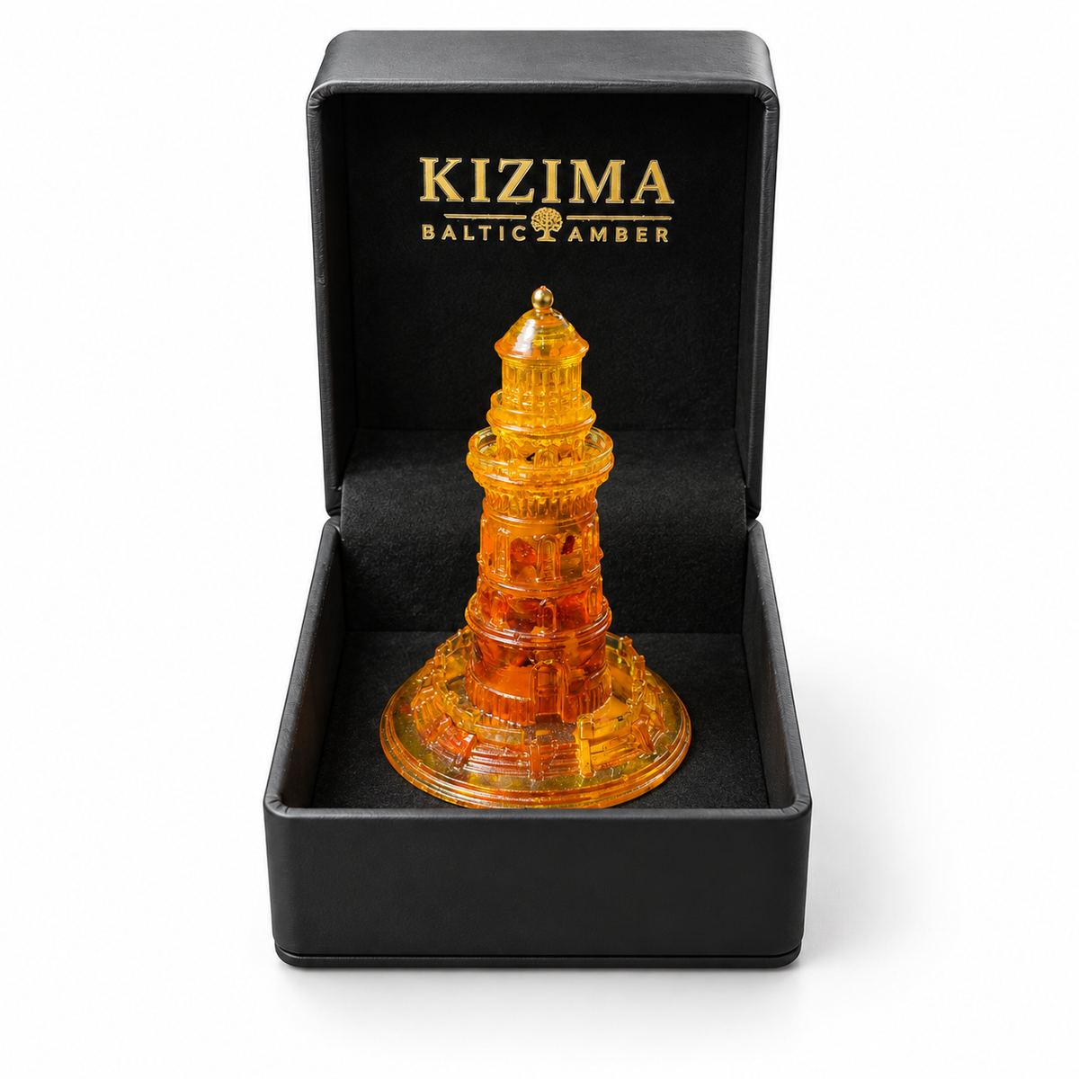 Ornate amber lighthouse presented in an open black KIZIMA gift box with gold branding on white.