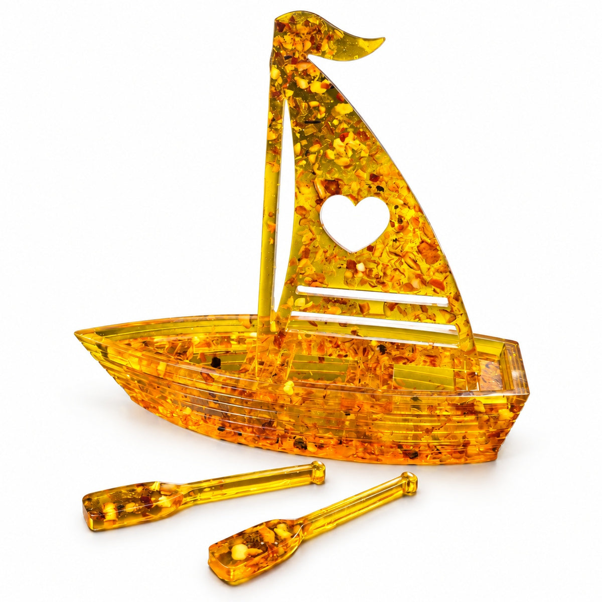 Honey-gold Baltic amber boat, heart sail design, shown with matching oars on a clean white background.