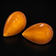 KIZIMA vintage honey-orange amber teardrop stud pair showing original inclusions and age marks on black.