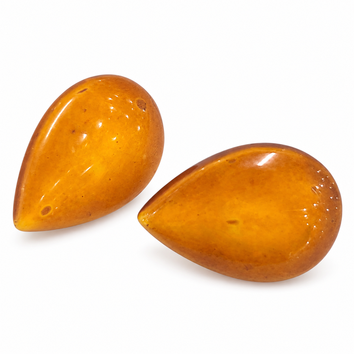 KIZIMA vintage amber teardrop studs in a diagonal pair arrangement on white, with their natural surface marks.