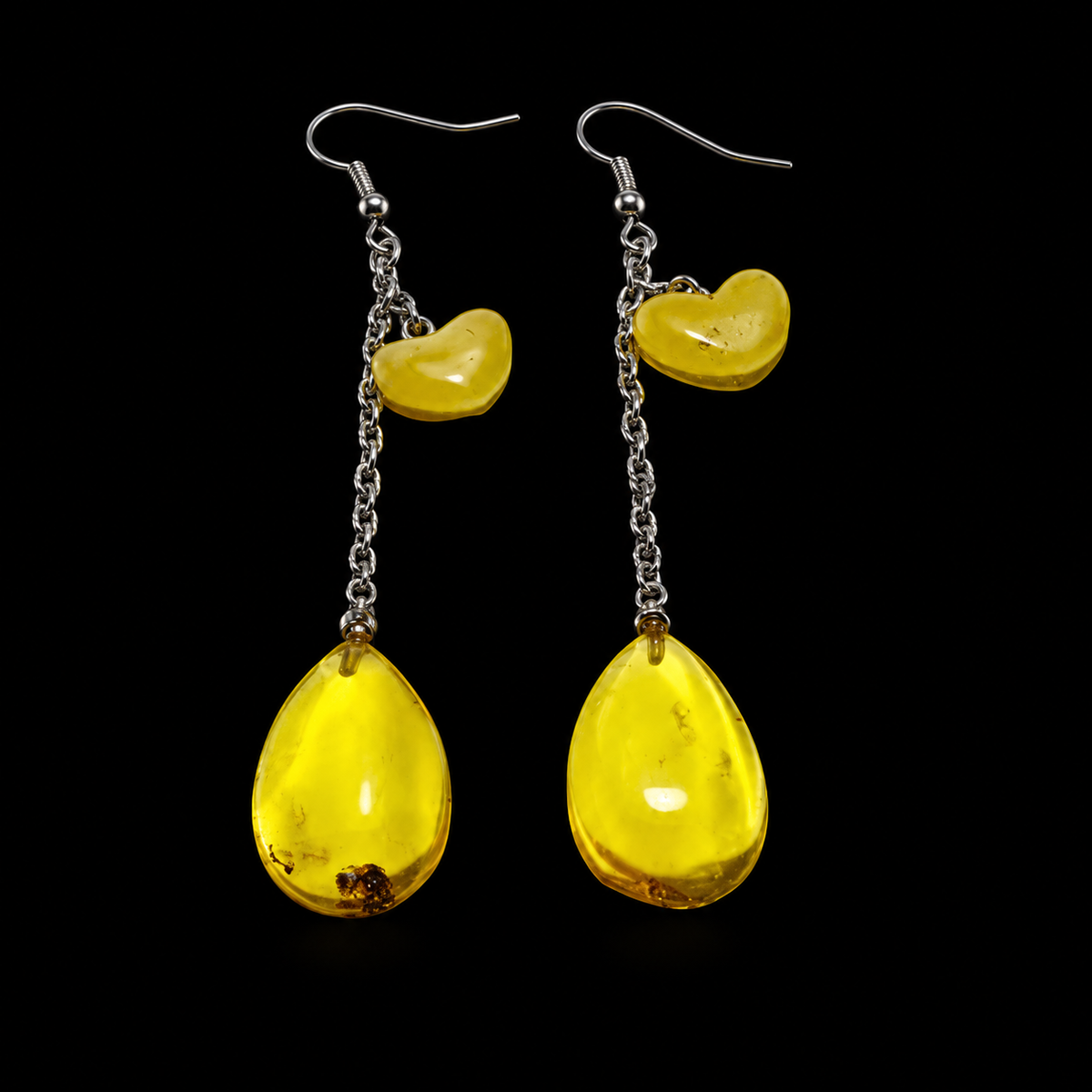 KIZIMA yellow amber chain-drop earrings with curved upper charms and natural dark inclusions on black.