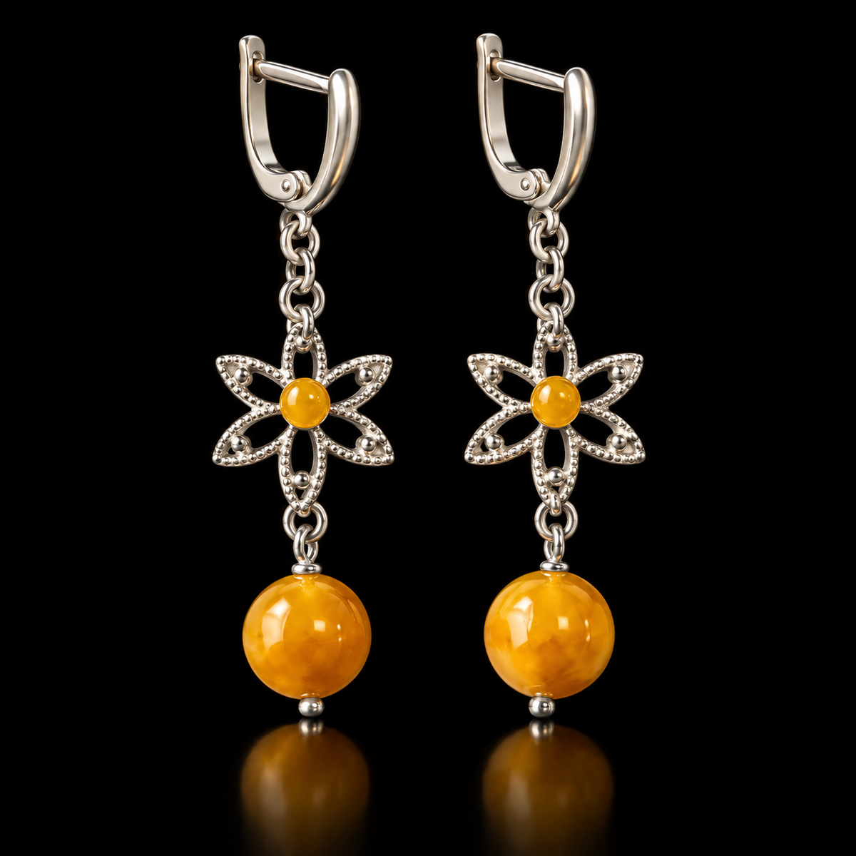 KIZIMA six-petal silver-tone flower earrings with yellow amber centers and round amber drops on black.