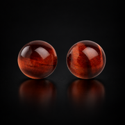 KIZIMA dark cognac Baltic amber hemisphere stud earring pair with natural reddish-brown striations, black studio view, SKU 5N0170q1.11.