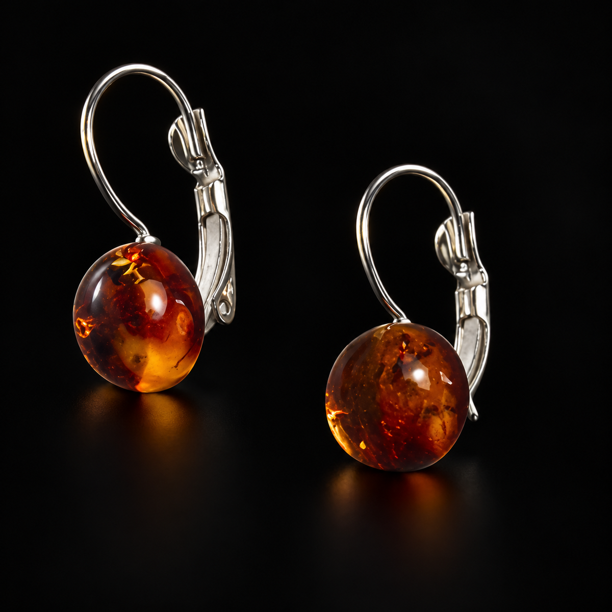 KIZIMA cognac Baltic amber hemisphere earring pair with silver-tone leverback clasps, black studio view, SKU 5N0200q11.86.