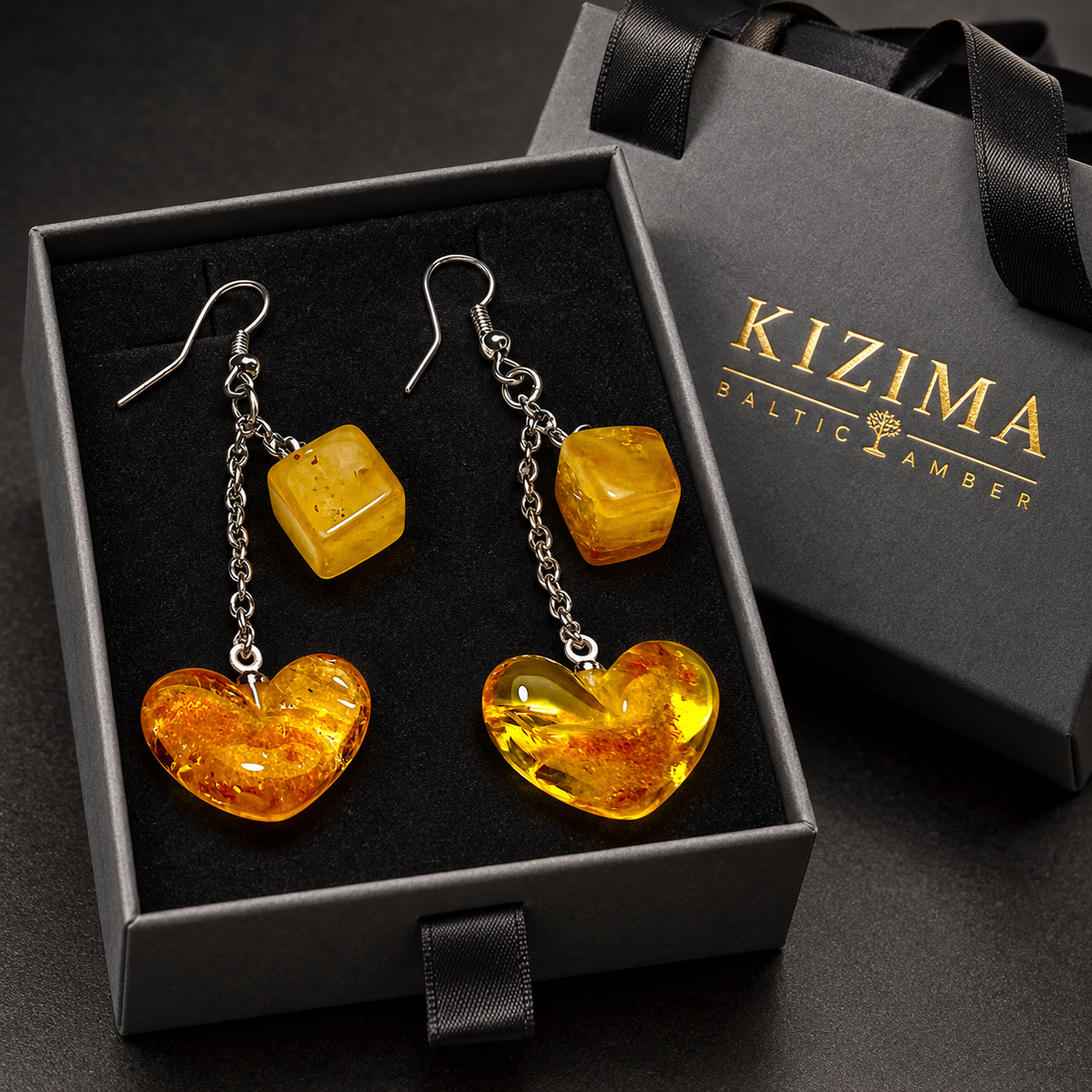 Golden amber cube and heart chain earrings in a charcoal gray KIZIMA ribbon-handle gift box with black insert.