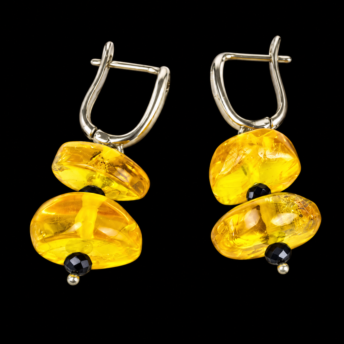 KIZIMA lemon-yellow Baltic amber double-disc earrings with black faceted spacers and leverback closures on a black studio background