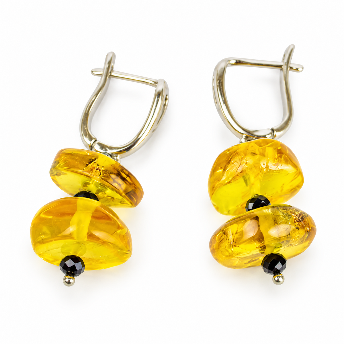 KIZIMA lemon-yellow Baltic amber double-disc earrings with black faceted spacers and leverback closures on a white background