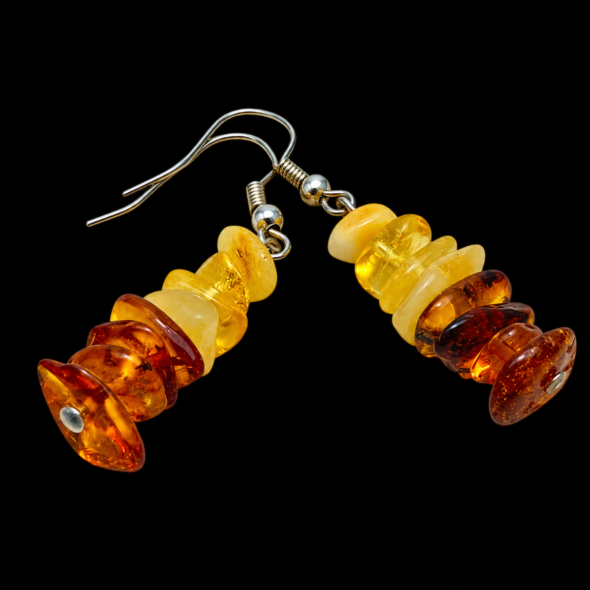 KIZIMA yellow and cognac Baltic amber chip drop earrings with silver-tone ear hooks on a black studio background