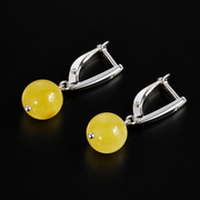 KIZIMA yellow amber ball earrings with silver-tone leverback clasps and small pin tips, black studio view, SKU 662987479004.