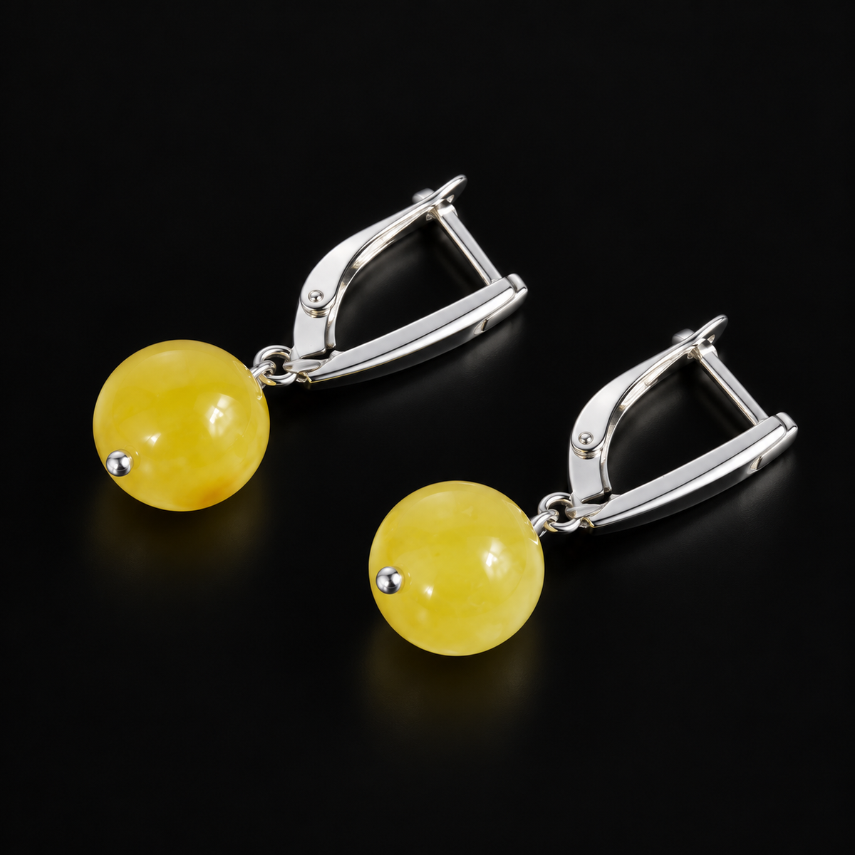 KIZIMA yellow amber ball earrings with silver-tone leverback clasps and small pin tips, black studio view, SKU 662987479004.