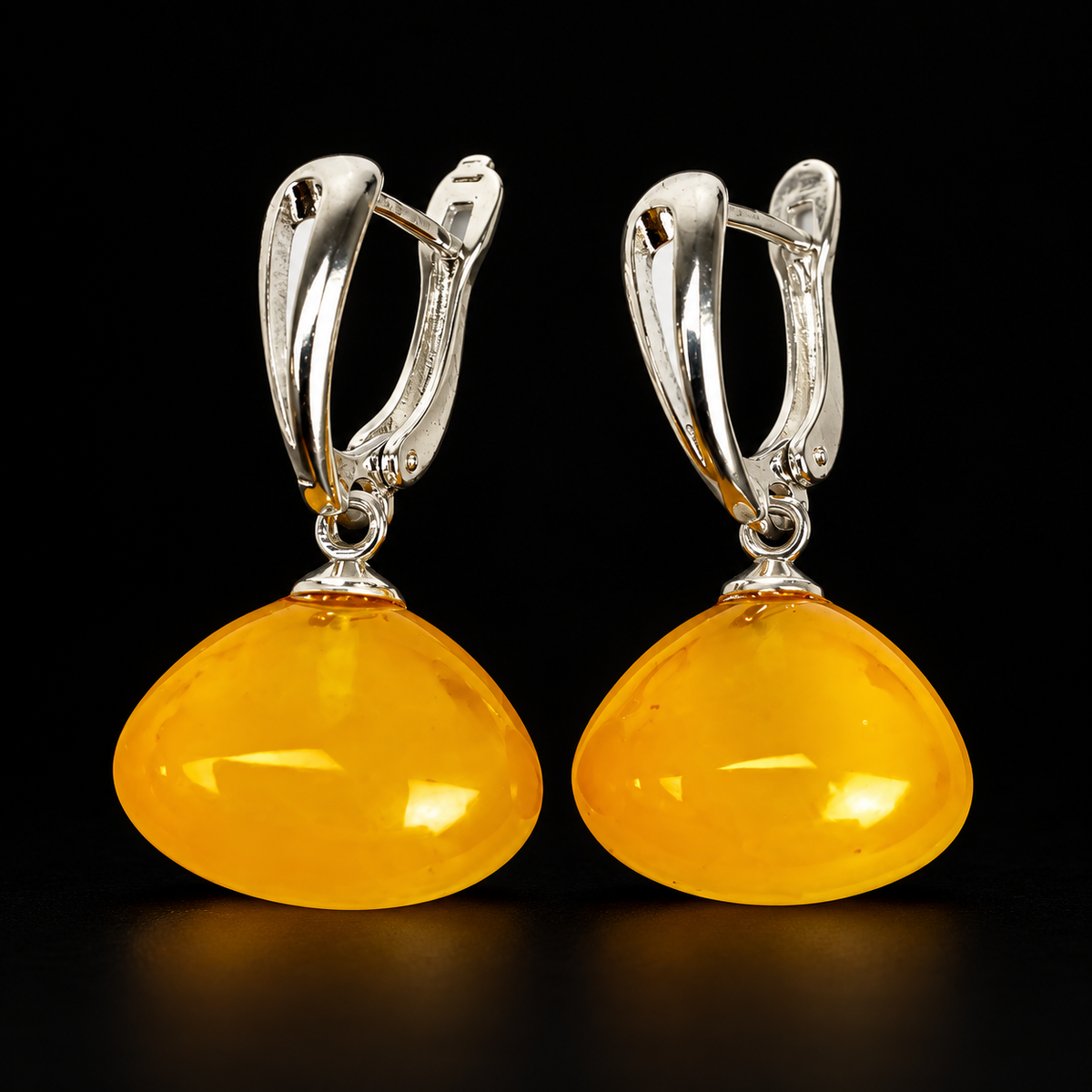 KIZIMA wide honey-yellow amber drop earrings with silver-tone leverbacks, photographed on black.