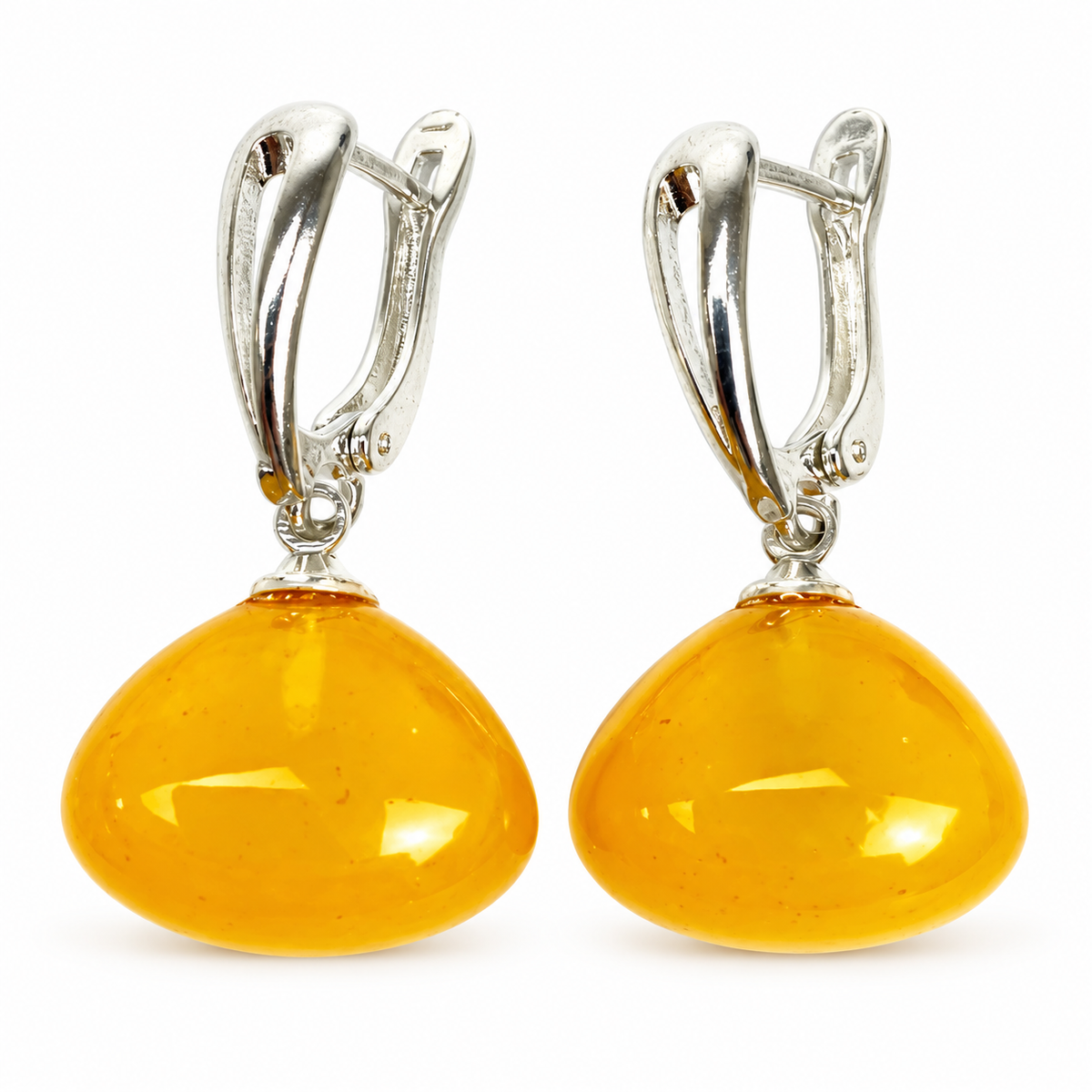 KIZIMA paired rounded honey amber drops and tapered silver-tone clasps isolated on pure white.