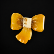 KIZIMA amber bow brooch on black studio background.
